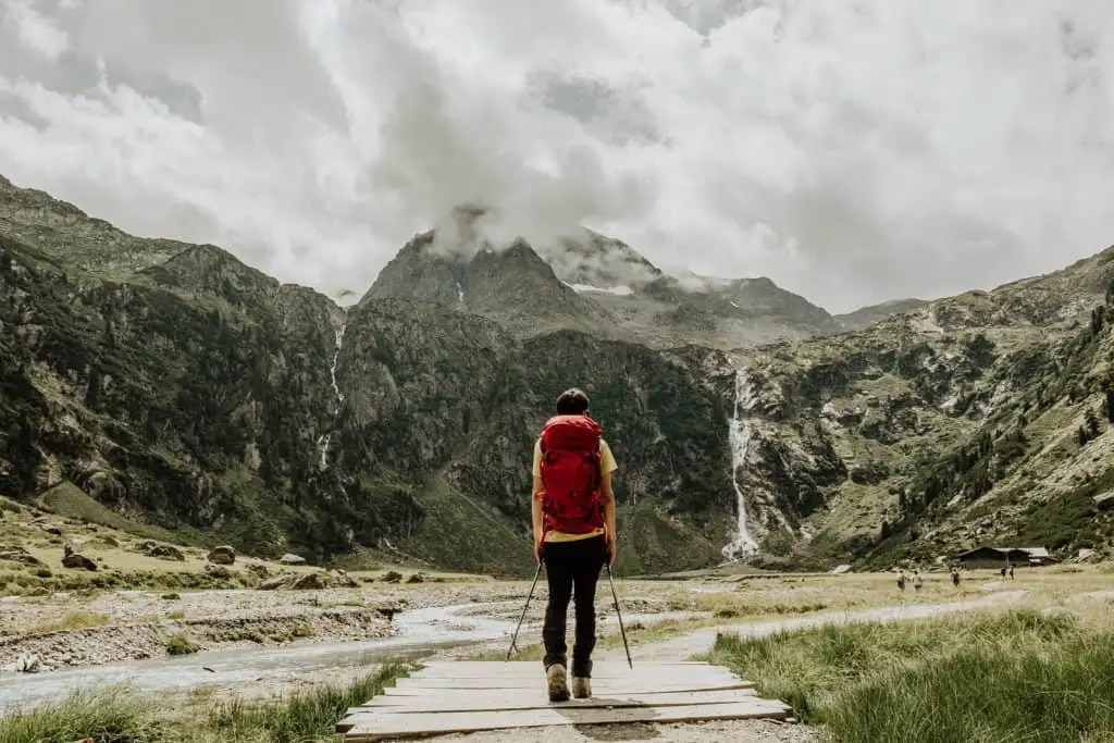 Man with red backpack hiking in the Alps