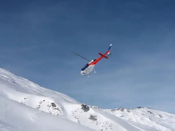 helicopter flying over snowy mountains in New Zealand