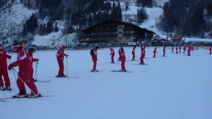 ski instructors line up to slatten the snow on the baby slope