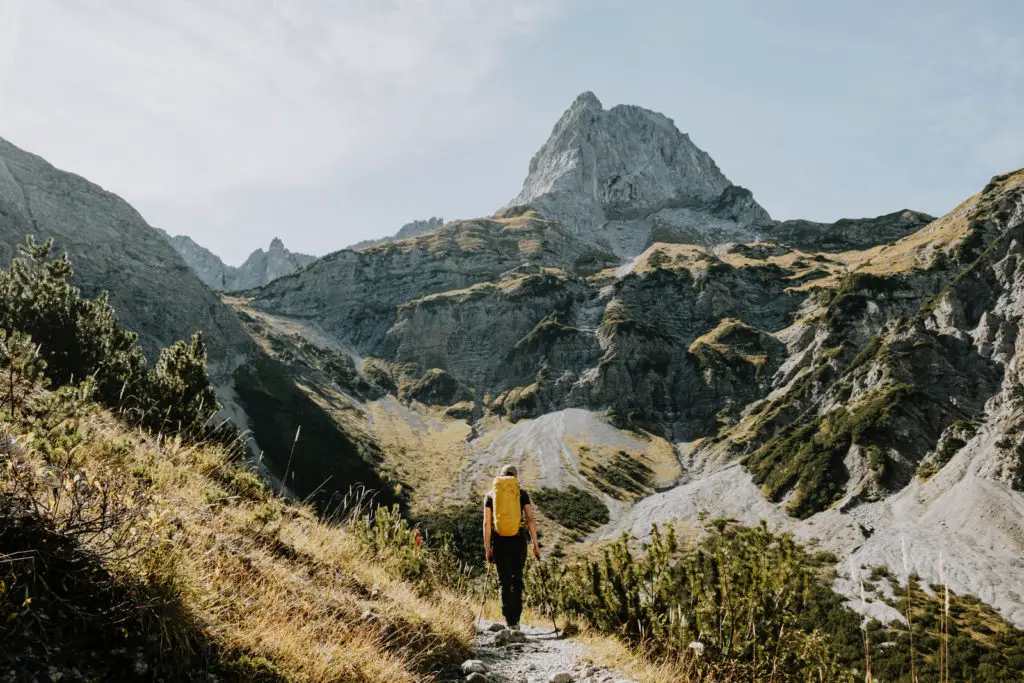 Man with a yellow backpack on a hiking trail in the Karwendal nature park in Austria
