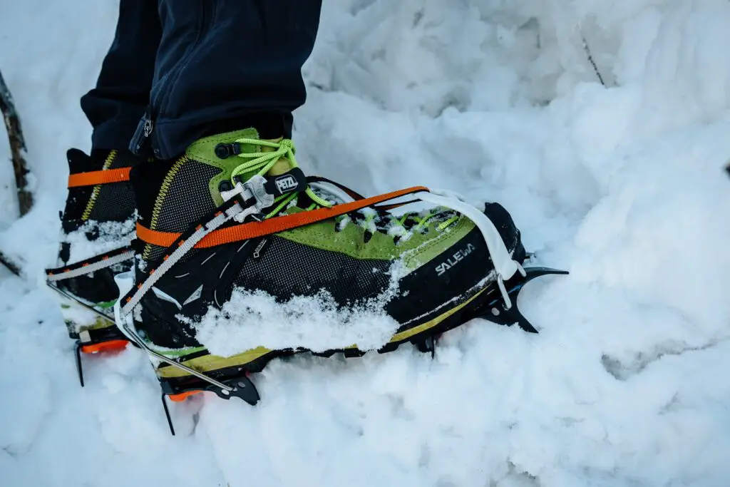 Close up of mountaineering boots with crampons attached in the snow
