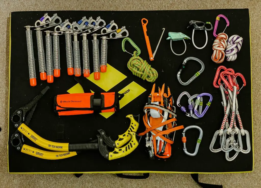 A photo showing a selection of ice climbing gear laid out on the floor