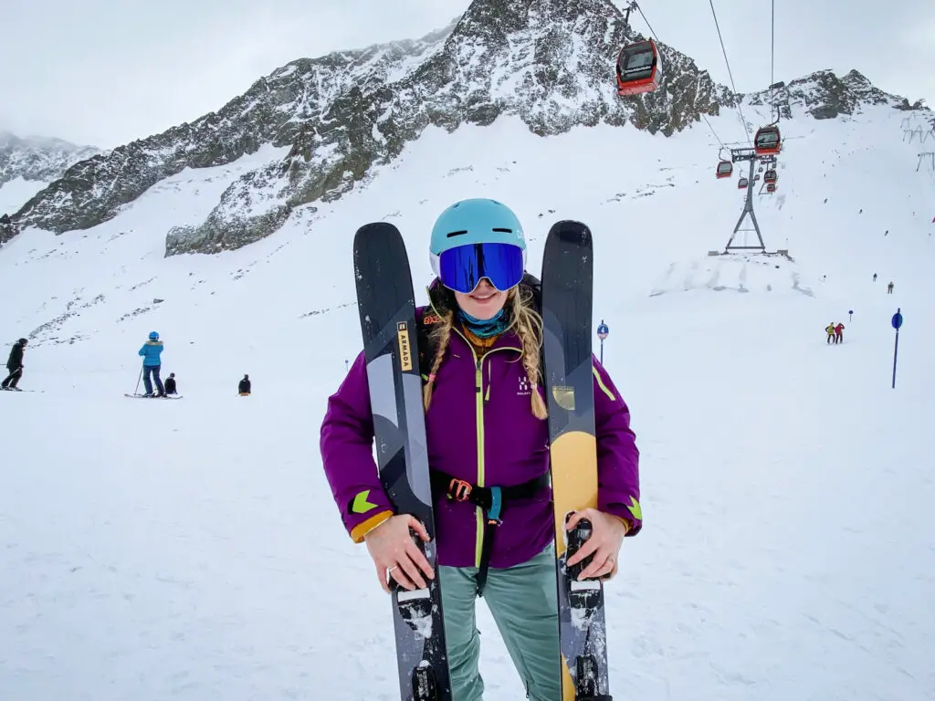 Woman holding the Armada Reliance 102 Ti Skis